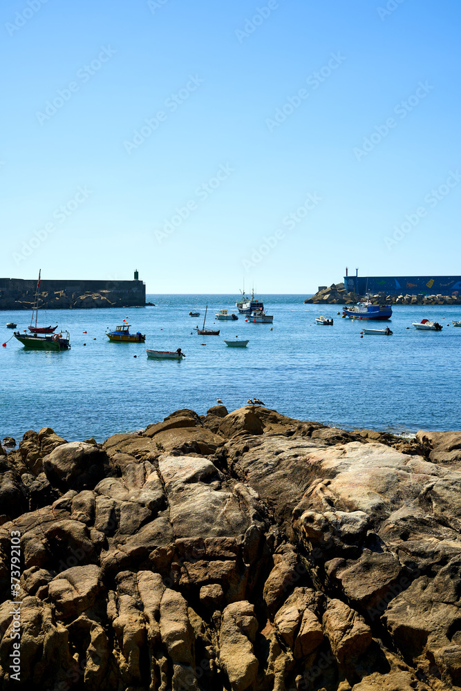seaport with blue waters and moored boats, with orange stones. Seaport with entrance to the sea and boats. Sea ​​port of a guarda