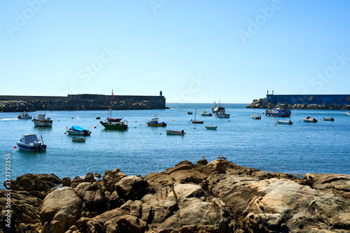 seaport with blue waters and moored boats, with orange stones. Seaport with entrance to the sea and boats