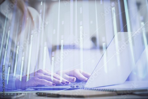 Double exposure of woman hands working on computer and forex graph hologram drawing. Financial analysis concept.