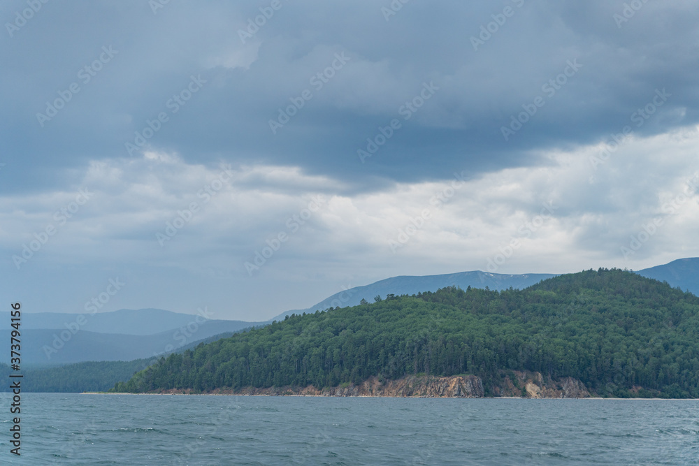 Russia, Irkutsk region, Baikal lake, July 2020: boat leaving splashes and traces on baikal water