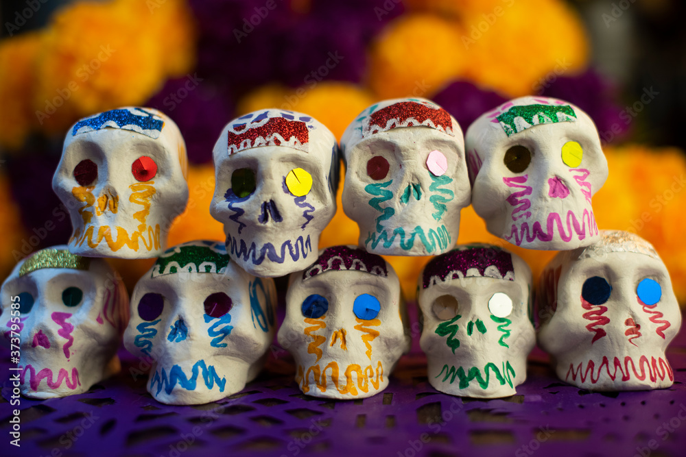 Calaveras de azúcar en fondo de cempasúchil y papel picado ofrenda día de muertos decoración tradición ancestral mexicana 