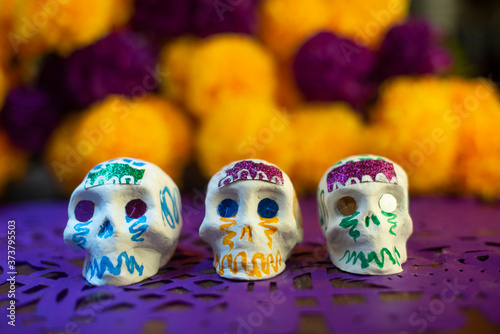 Calaveras de azúcar en fondo de cempasúchil y papel picado ofrenda día de muertos decoración tradición ancestral mexicana 
