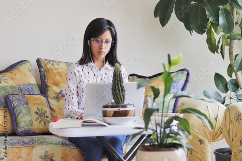 Woman types on laptop while working from home photo