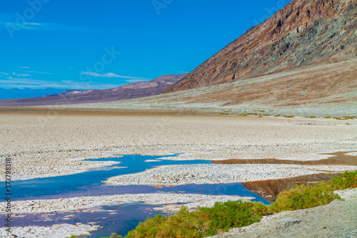 Reflection of The Black Mountains in The Alkaline Water of Bad Water Pool at Bad Water Basin, Death Valley National Park, California, USA
