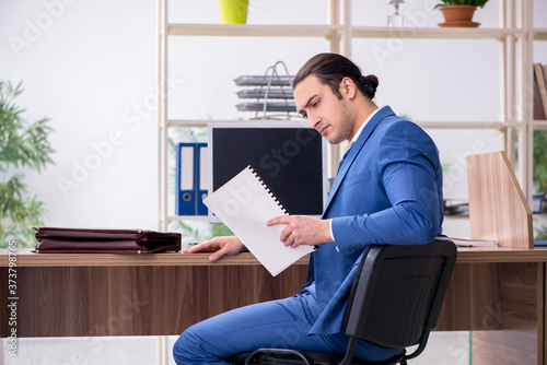 Young male employee businessman at workplace