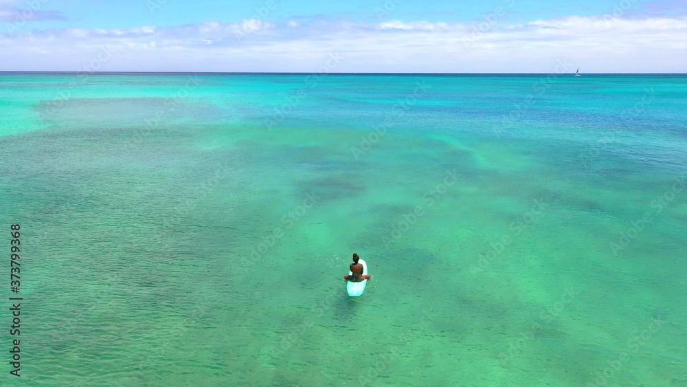 A photo of the back of a woman surfer who is waiting a wave A photo of the back of a woman surfer who is waiting a wave