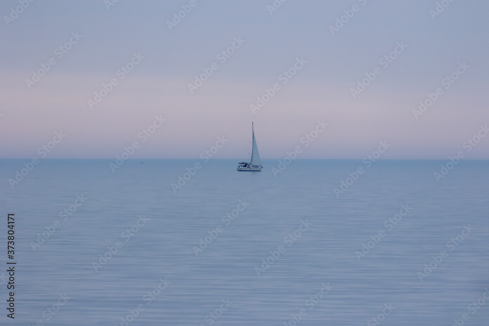 The sailboat in the evening haze on the lake Michigan.