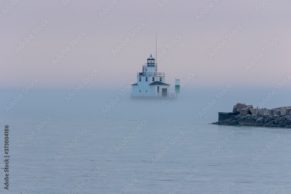 The lighthouse in the evening haze on the lake Michigan