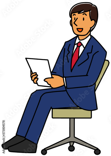 椅子に座って話すスーツ姿の男性
