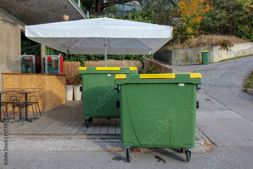 green plastic trash containers, residential area new building.