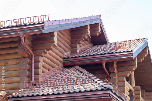 Close-up detail of new modern wooden warm ecological cottage house top with shingled brown roof.