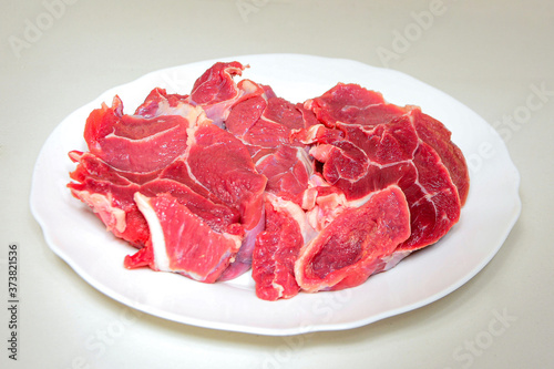 Raw beef meat steak on white plate on light background close up. Carnivore, keto