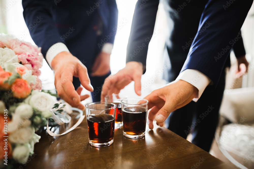 Business meeting. Men hold glasses of whiskey. Men's Party. Hand with a drink of alcohol