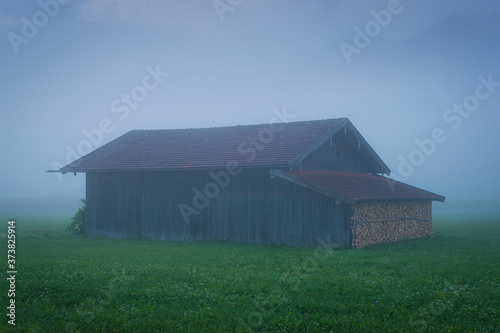 Hütte auf Feld in den Bergen im Nebel - Krün im Karwendel photo