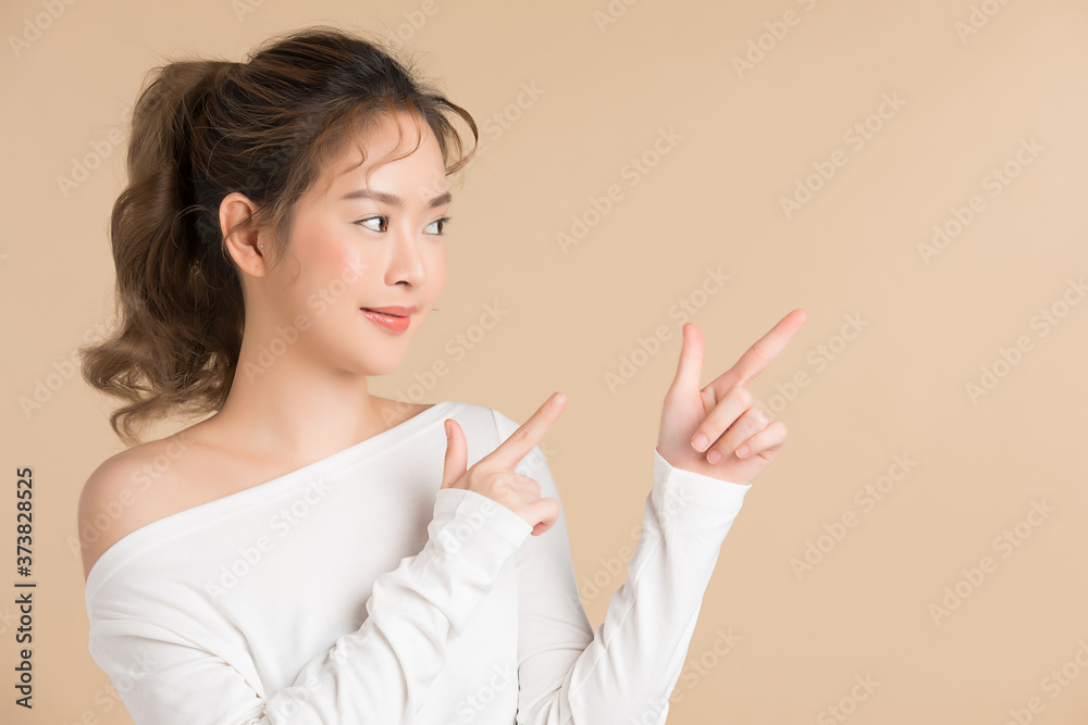 Young female model posing with hands gesture isolated on brown studio background Young female model posing with hands gesture isolated on brown studio background