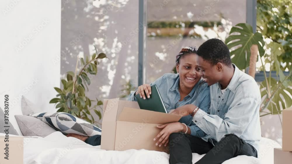 A frican-American wife and husband are unacking staff. They are getting out books and reading. A frican-American wife and husband are unacking staff. They are getting out books and reading.