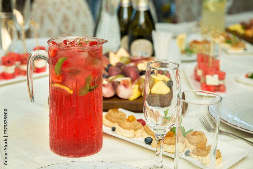 Cold summer drink with ice, strawberries and mint on the table