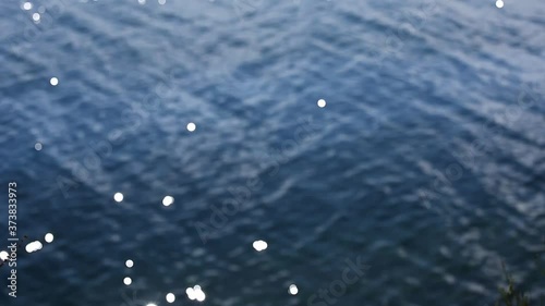 Bokeh sun glare reflected in water surface. Abstract blurry out of focus bokeh background imagery