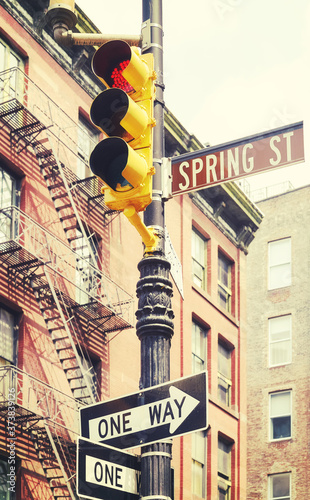 New York City street signs and traffic lights at Spring Street, color toned picture, USA.