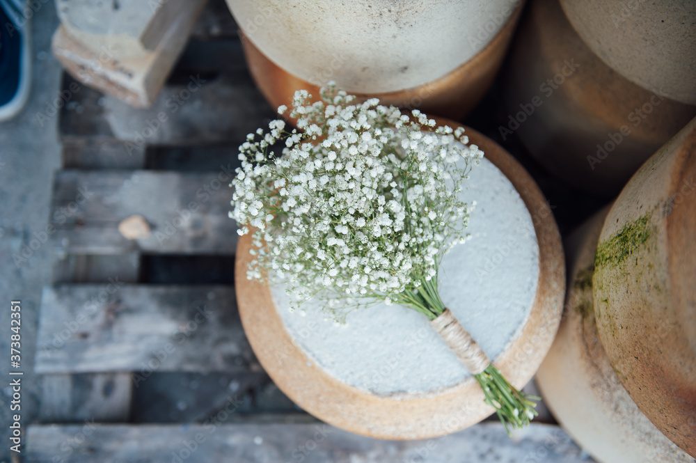 A beautiful wedding bouquet of gypsophila lies on a clay jug A beautiful wedding bouquet of gypsophila lies on a clay jug