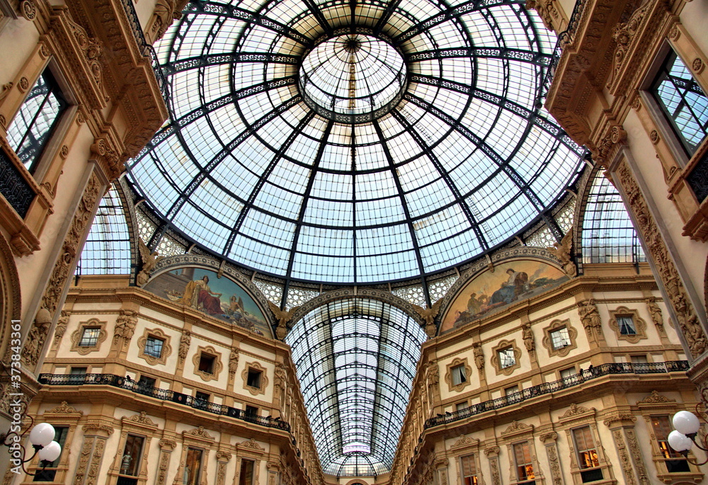 Panorama inside the Galleria Vittorio Emanuele II in Milan. This gallery is famous shopping mall and Milan landmark. Beautiful interior of the old Milan store in summer.