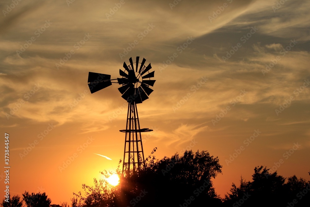 Kansas Sunset with a colorful sky and clouds with a Windmill silhouette north of Hutchinson Kansas USA. Kansas Sunset with a colorful sky and clouds with a Windmill silhouette north of Hutchinson Kansas USA.
