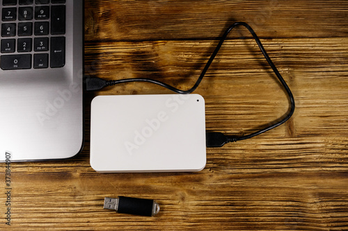 Fényképezés External HDD connected to laptop computer and USB flash drive on a wooden desk
