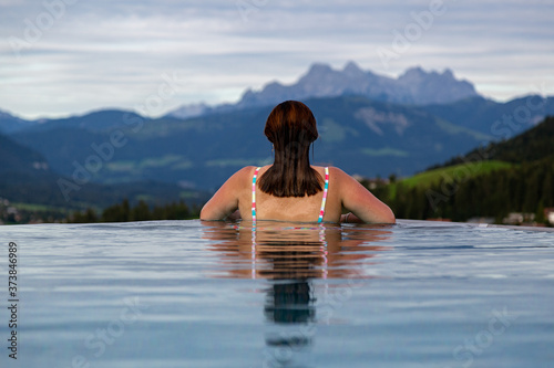 woman looks to the mountain out of an infinity pool