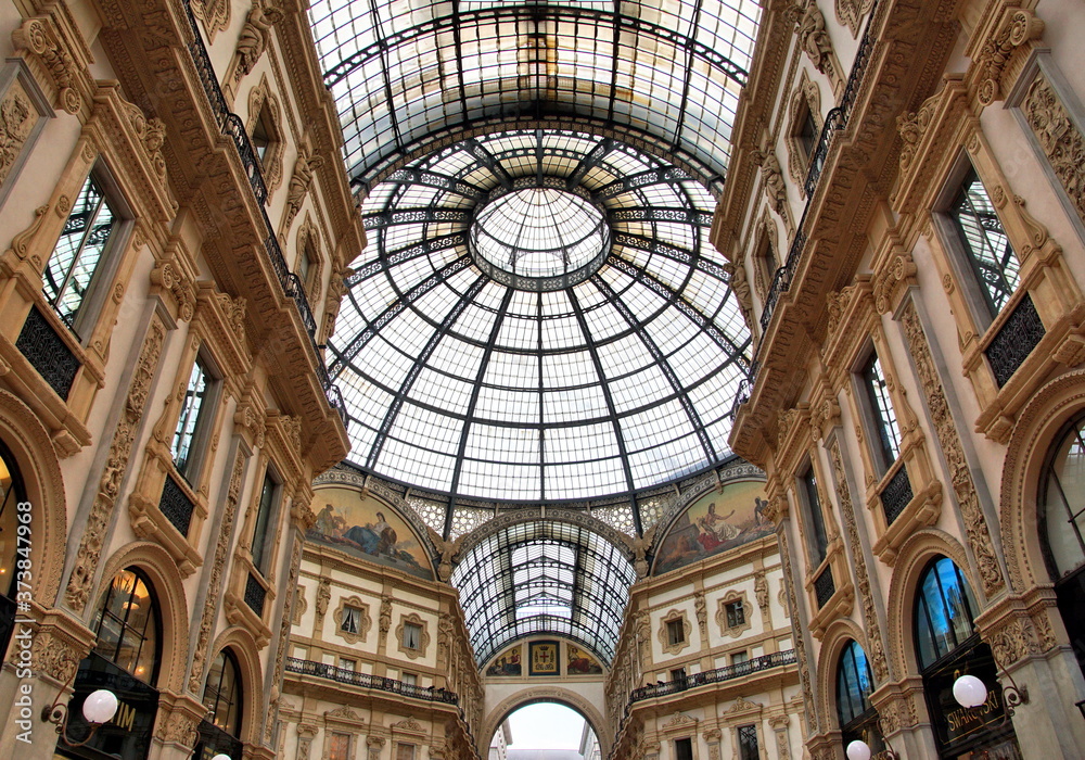 Panorama inside the Galleria Vittorio Emanuele II in Milan. This gallery is famous shopping mall and Milan landmark. Beautiful interior of the old Milan store in summer.