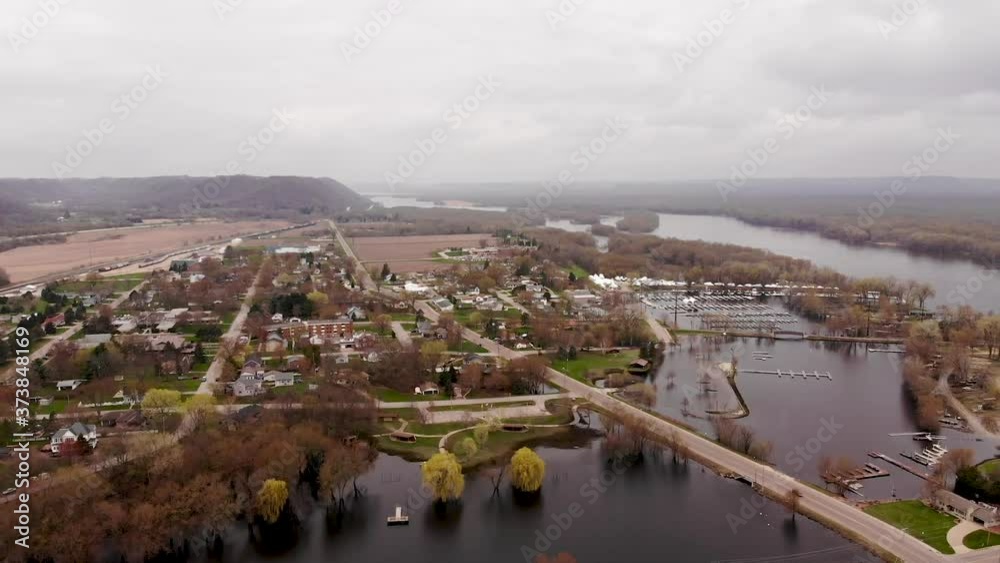 Aerial view of flooded city park with overflowing river in Wabasha Minnesota. Flying over flooded city on the river banks with submerged walkways and city park in a small town. Aerial view of flooded city park with overflowing river in Wabasha Minnesota. Flying over flooded city on the river banks with submerged walkways and city park in a small town.