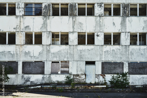 Abandoned former administration building, slowly decaying, without windows and panes, ugly, weathered