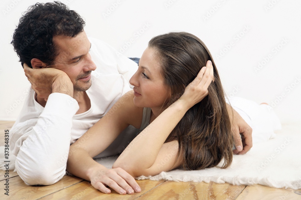 Man and woman lying sideways, looking at each other Man and woman lying sideways, looking at each other