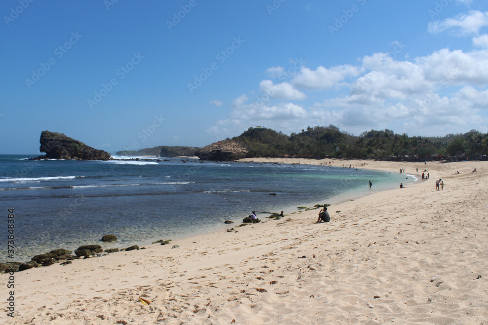 beautiful watu karang beach in Pacitan, with a background of blue sky with clouds and white sands, East Java, Indonesia