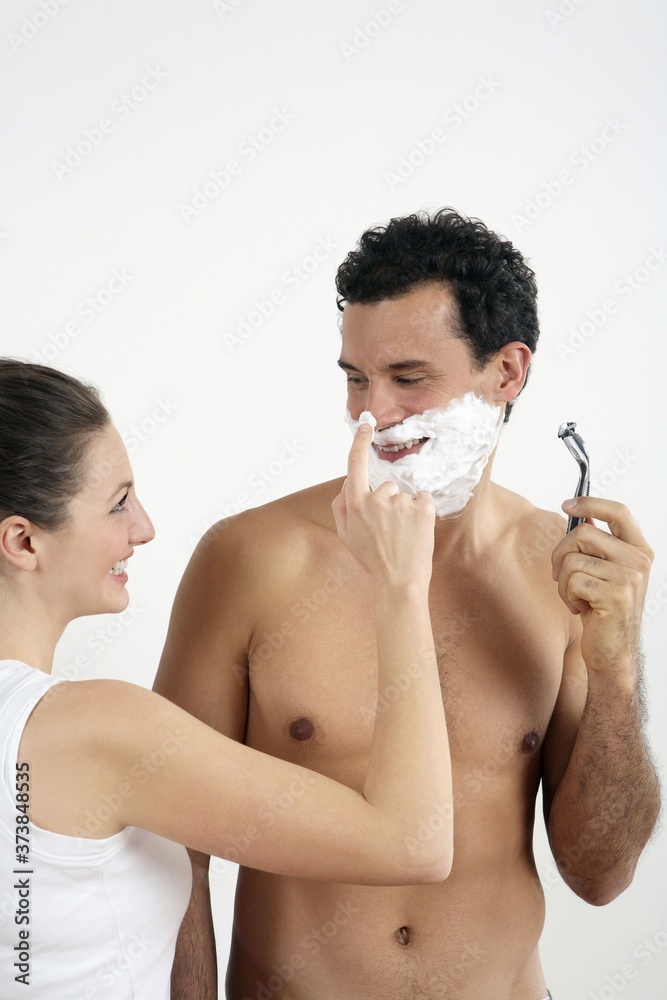 Woman disturbing man shaving