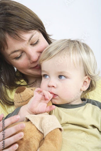 Mother hugging son with a teddy bear