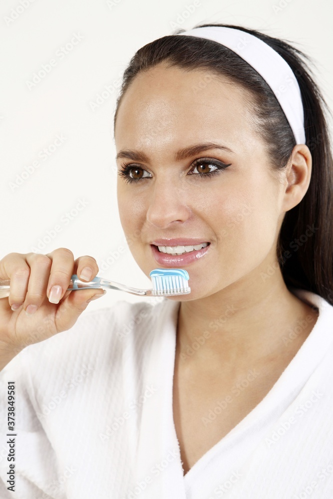 Woman in bathrobe about to brush her teeth Woman in bathrobe about to brush her teeth