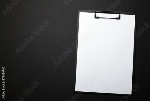Blank paper on black clipboard with space on black background