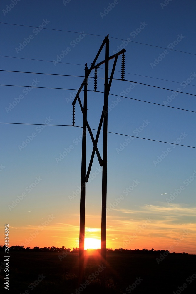 Kansas colorful Sunset with clouds and sky with power lines and poles silhouettes Kansas colorful Sunset with clouds and sky with power lines and poles silhouettes