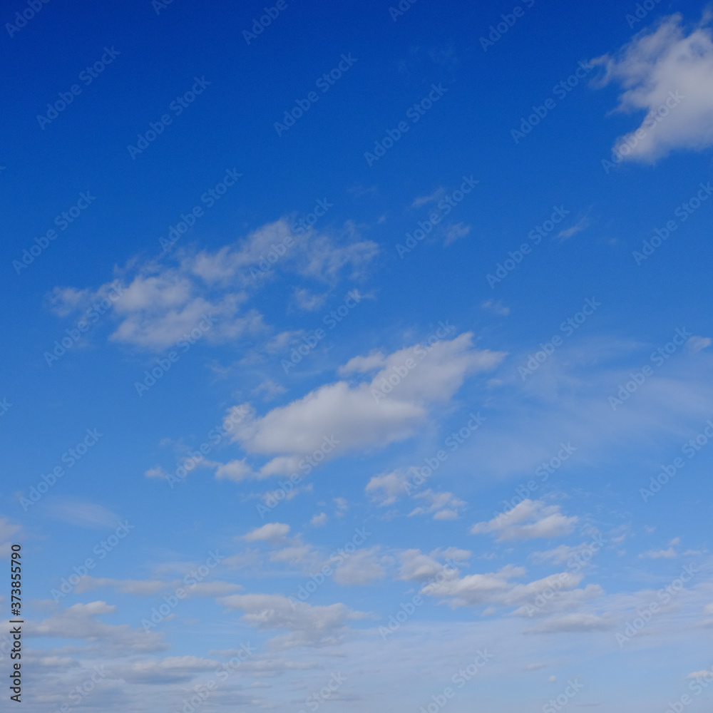 Blue spring sky with white clouds. Beautiful background.