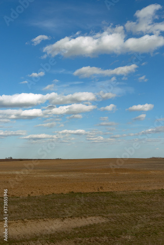 Beautiful cloudy sky over farmland. Spring landscape.