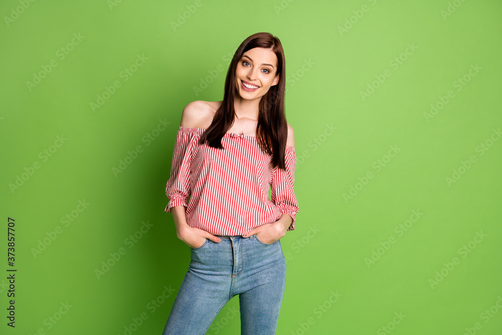 Photo of adorable funny young girl look hands pockets shiny smile prepare forest morning walk wear jeans striped white red blouse uncovered shoulders bright green color background Photo of adorable funny young girl look hands pockets shiny smile prepare forest morning walk wear jeans striped white red blouse uncovered shoulders bright green color background