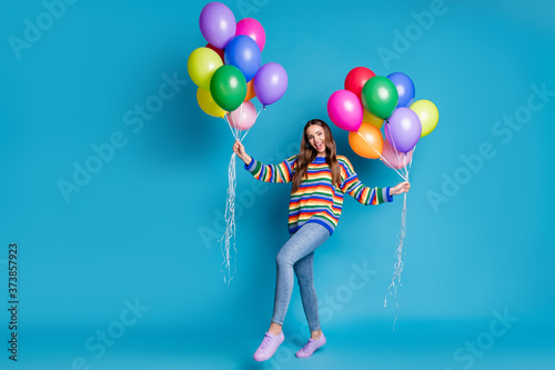 Yeah i win birthday party. Full body photo of energetic crazy girl enjoy rejoice anniversary celebration hold many helium balloons wear good look mood outfit isolated blue color background