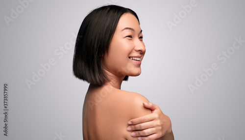 Happy Asian model embracing shoulder