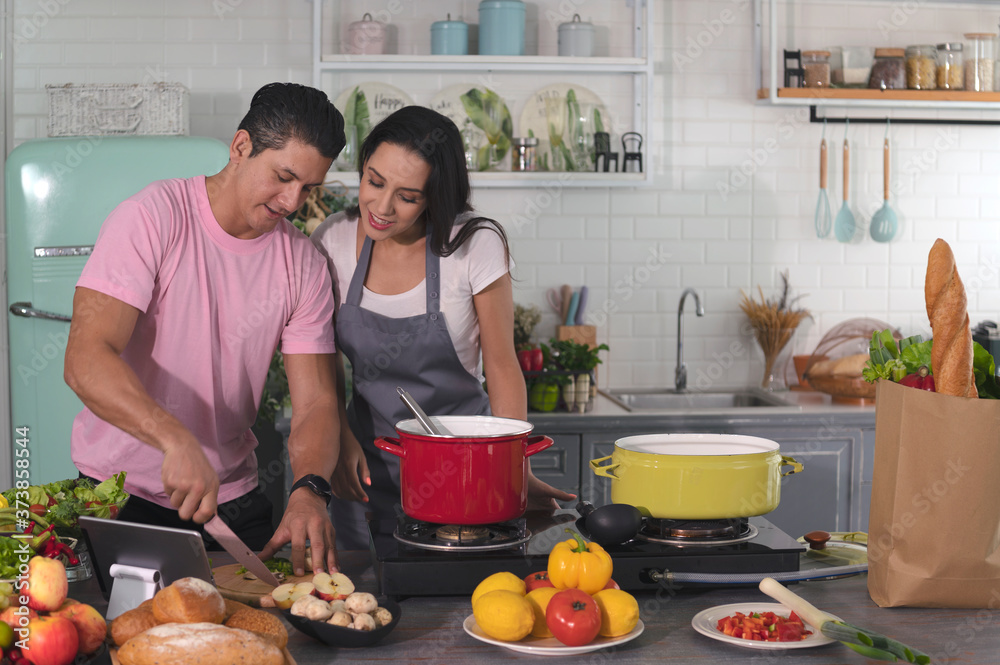 Φωτογραφία Happy adult couples cooks a organic homemade meal in a family kitchen together w