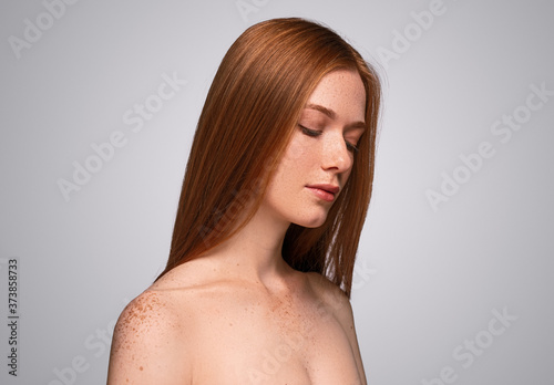 Calm woman with freckled skin