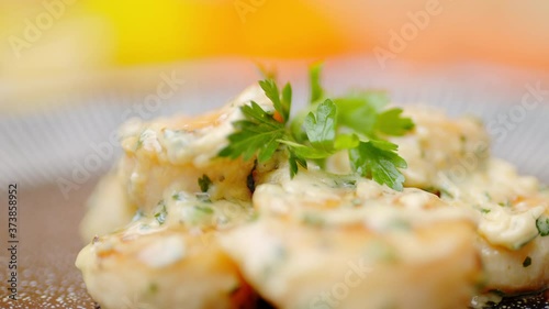 Close-up of a chef adding greens on top of the scallops in a serving plate. Concept of serving scallops by a chef in slow-motion in 4K.