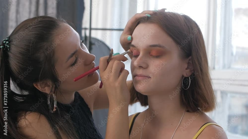 Make-up artist applying makeup to model's face Close up view. Make-up artist applying makeup to model's face Close up view.