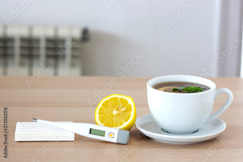 Hot tea for colds, lemon, pills, thermometer and handkerchiefs. Seasonal diseases, colds and flu concept