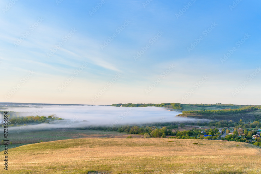 sunrise, fog over the river panorama of the landscape in the early morning. thick fog is illuminated by the sun's rays in summer