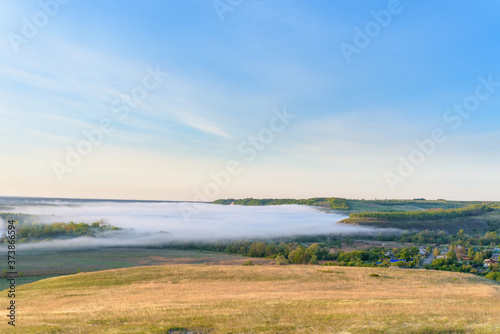 sunrise, fog over the river panorama of the landscape in the early morning. thick fog is illuminated by the sun's rays in summer